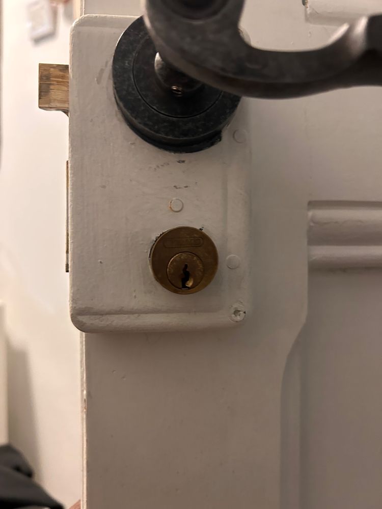 Serrure blanche en applique avec cylindre en laiton après une ouverture de porte pour perte de clés