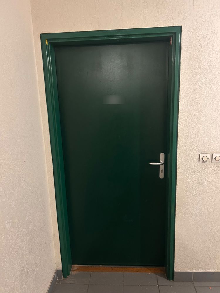Nouvelle porte verte posée en remplacement de la porte endommagée après effraction
